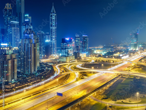 Scenic nighttime skyline of big modern city with illuminated skyscrapers. Aerial view of Dubai Marina, UAE. Multicolored travel background. © Funny Studio