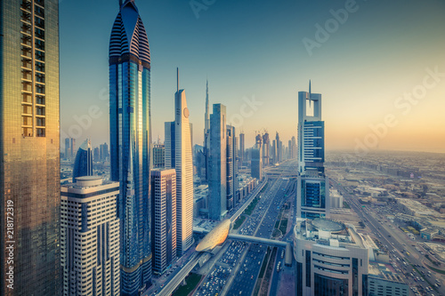 Skyscrapers and highways of a big modern city at sunset. Aerial panoramic view on downtown Dubai, United Arab Emirates.