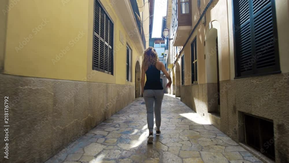 Rear view tourist woman Walking narrow streets of Barcelona Wearing cute summer dress enjoying European summer holiday travel vacation adventure Rear view tourist woman Walking narrow streets of Barcelona Wearing cute summer dress enjoying European summer holiday travel vacation adventure