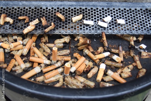Ausgedrückte Zigaretten in einem öffentlichen Aschenbecher