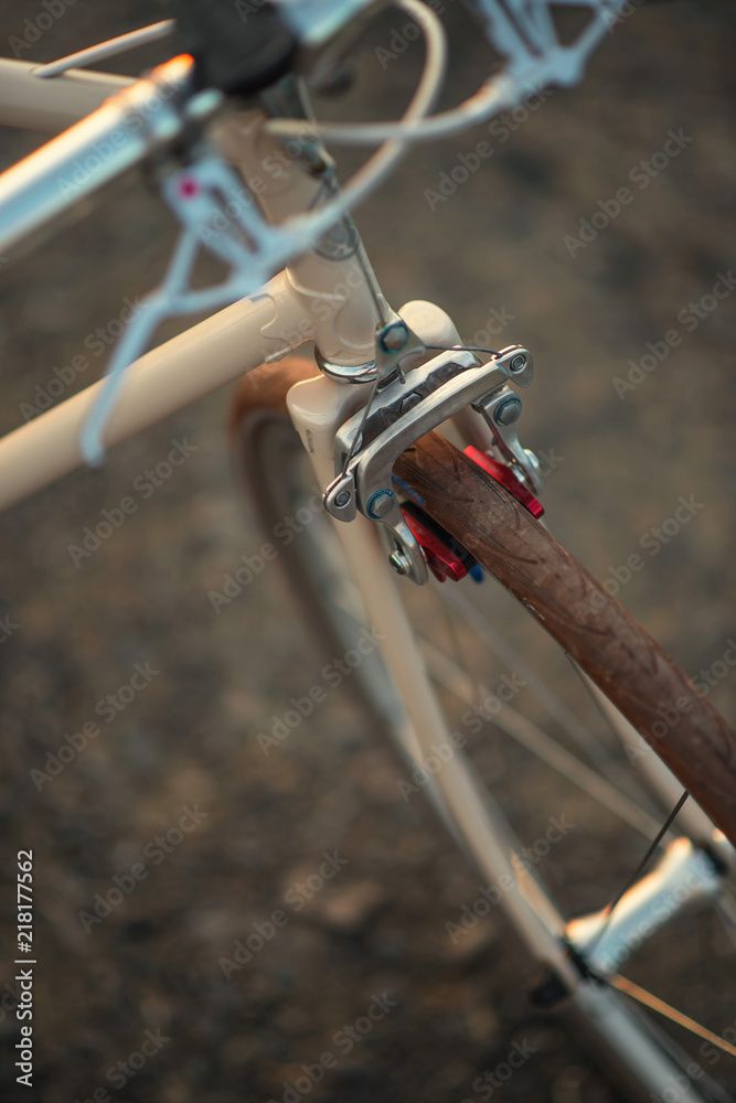 Naklejka premium Retro bicycle on the road in sunset, detail photography of bike components