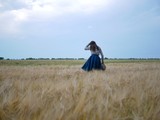 Polonne / Ukraine - July 12 2018: Young and beautiful girl walking through a wheat field