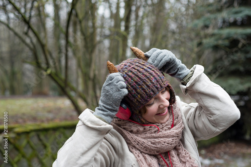 Funny Woman in hat and headphones listening to music in the outdoors