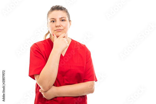 Obraz na plátně Young medical nurse wearing red scrub showing reflecting gesture.