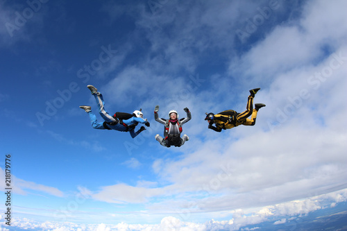 Skydiving. Two instructors are training a student to fly.
