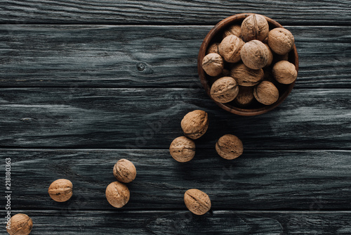 delicious walnuts in wooden bowl on dark wooden tabletop