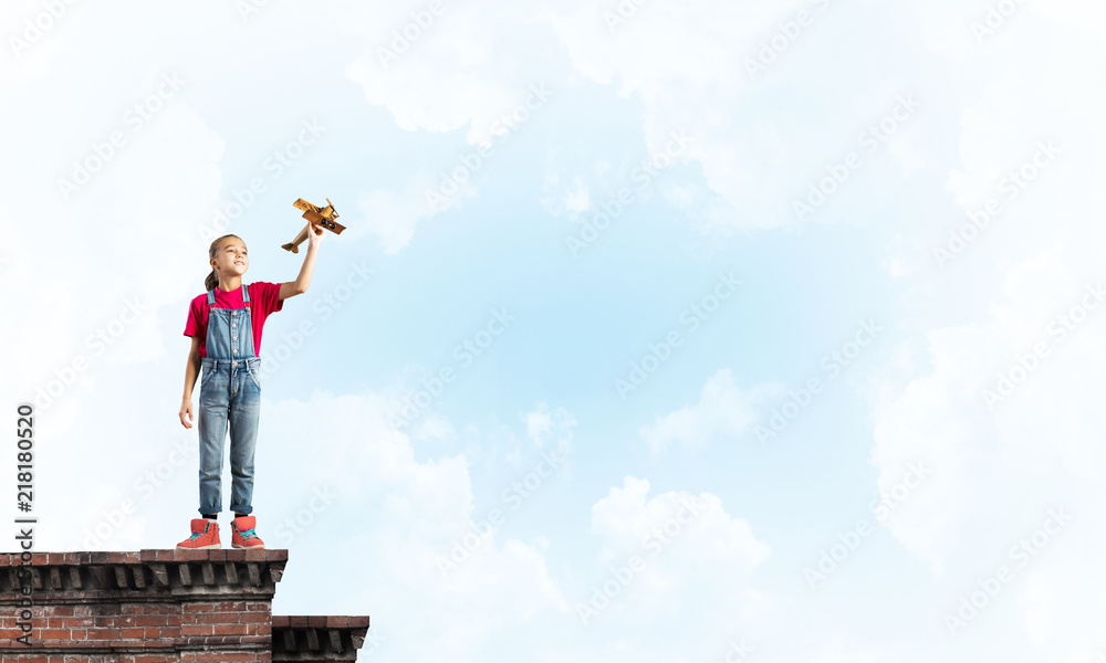 Concept of careless happy childhood with girl dreaming to become pilot Concept of careless happy childhood with girl dreaming to become pilot
