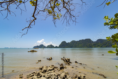 Sea beach on sount islands in Thailand with a natural rock and tree in the foreground. photo