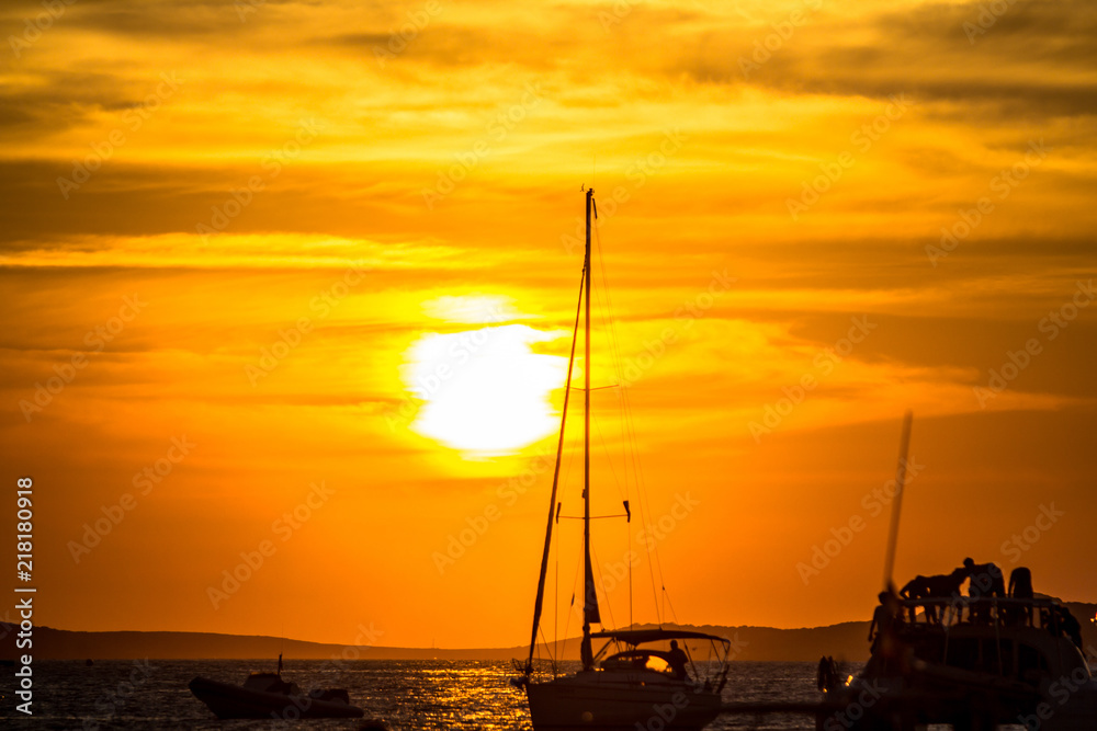 Sunset over sea with silhouettes of yachts
