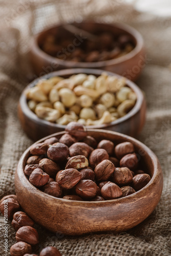 various nuts in wooden bowls on sackcloth