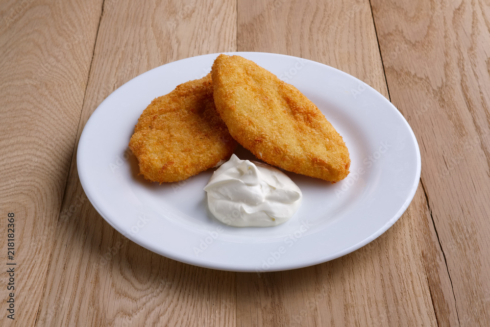 Potato cutlet in breading stuffed with ham served with sour cream Potato cutlet in breading stuffed with ham served with sour cream
