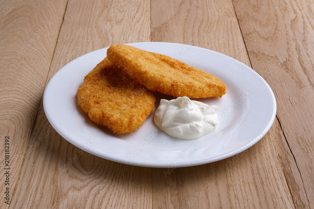 Potato cutlet in breading stuffed with ham served with sour cream Potato cutlet in breading stuffed with ham served with sour cream