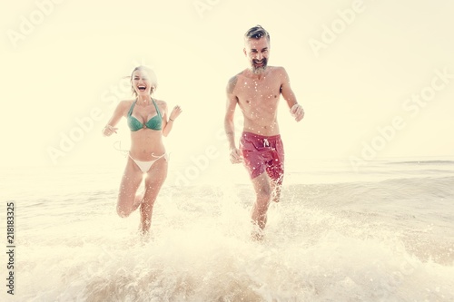 Cheerful couple running at the shore