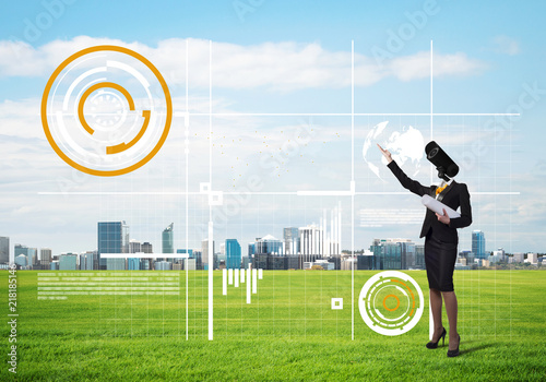 Camera headed woman standing on green grass against modern cityscape