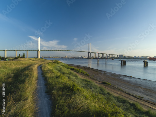 Drone shot above over grass on Thames riverbank with QEII bridge photo