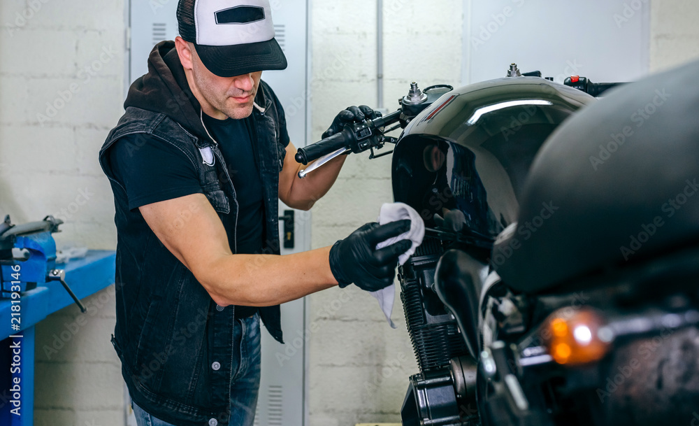 Fototapeta premium Mechanic cleaning a customized motorcycle in his workshop