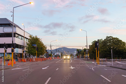 Intersection with car approaching, during sunset