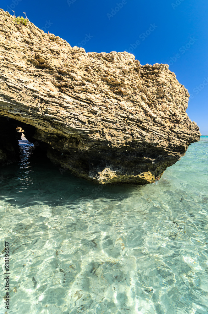 Fototapeta premium Beautiful crystal clear water at Cittadella dei Maccari, San Lorenzo, Nature Reserve Oasis of Vendicari, Syracuse, Sicily, Italy, Dreamy and idyllic spring holiday destination near Noto and Marzamemi.