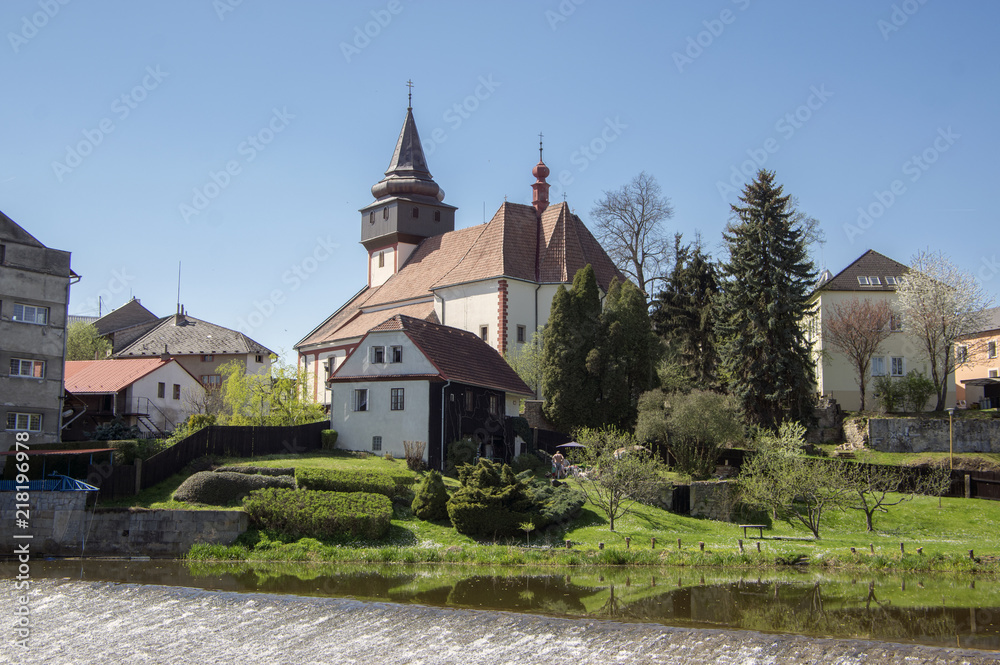 Church of St. Wenceslas in town Svetla nad Sazavou, clock tower, greenery and blue sky, river Sazava