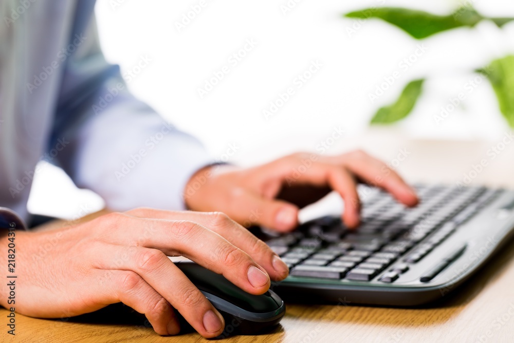 Closeup of an Employee Typing on Keyboard and Holding Mouse Closeup of an Employee Typing on Keyboard and Holding Mouse