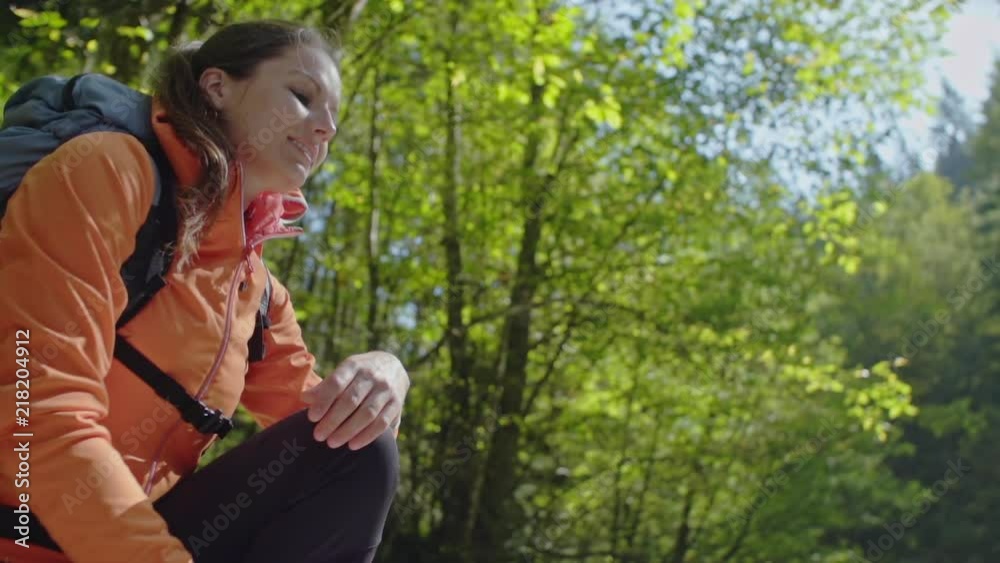 Female hiker splashes her face with cool clear water from a mountain stream in slowmotion. Female hiker splashes her face with cool clear water from a mountain stream in slowmotion.