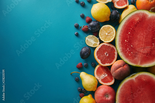 top view of grapefruits  lemons and berries on blue surface