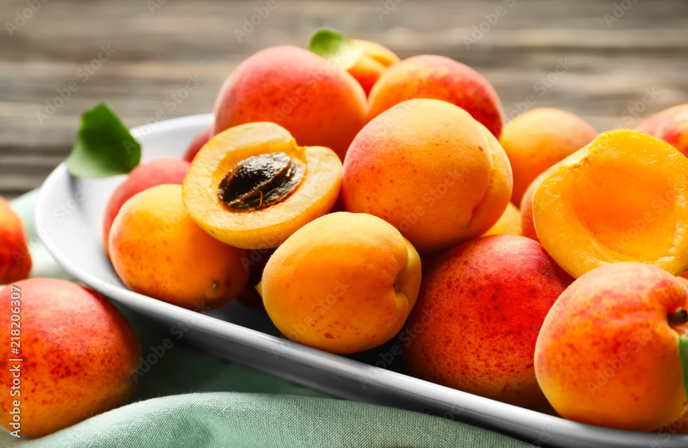 Plate with ripe sweet apricots on table, closeup Plate with ripe sweet apricots on table, closeup