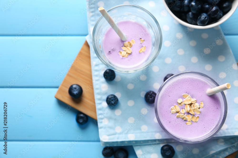 Glasses with tasty blueberry smoothie on color wooden table Glasses with tasty blueberry smoothie on color wooden table