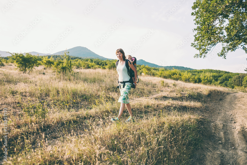 A woman is carrying a backpack with her baby. A woman is carrying a backpack with her baby.