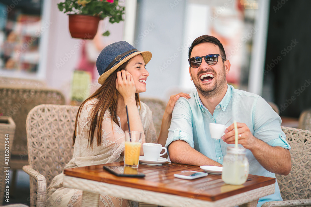 Beautiful loving couple sitting in a cafe enjoying in coffee and conversation Beautiful loving couple sitting in a cafe enjoying in coffee and conversation