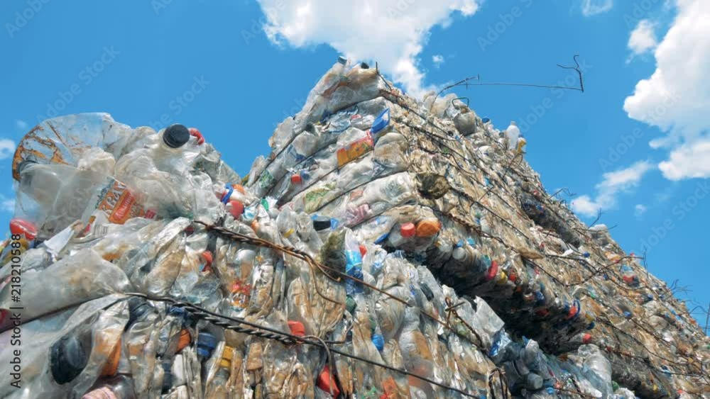 Used plastic bottles storaged in pressed blocks outdoors ready for recycling. Waste recycling concept.