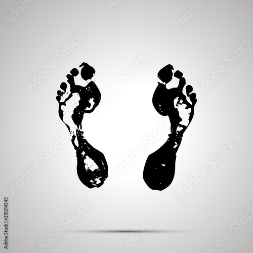 Imprints of bare human foots, simple black icon with shadow on gray