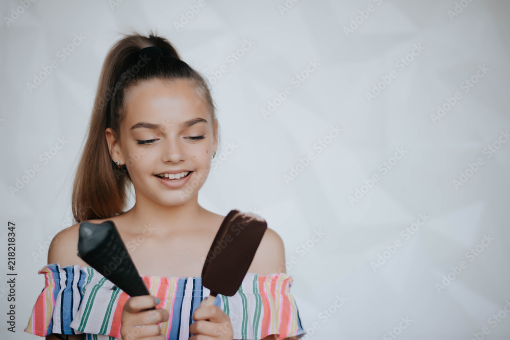 Happy girl eating ice cream. Young hipster girl eating a delicious ice cream in summer hot weathe. Chocolate. Cream. Ice. Sweet Tooth Happy girl eating ice cream. Young hipster girl eating a delicious ice cream in summer hot weathe. Chocolate. Cream. Ice. Sweet Tooth