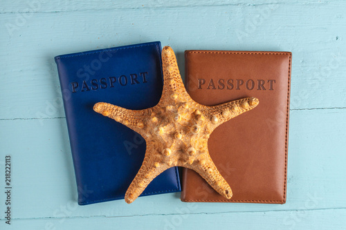 The concept of travel, recreation, cruise. Holidays. Passports, seashells, starfish on a blue, wooden background. Top view. Toutism photo