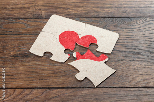 Parts of the puzzle form the heart, broken. The concept of divorce, quarrel, conflict. photo