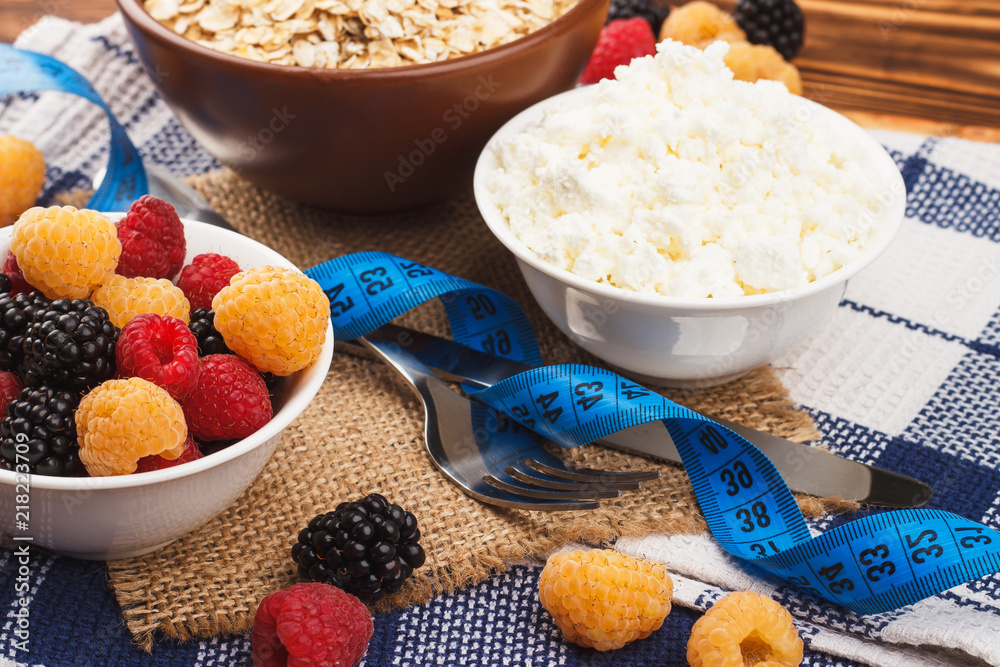 Oatmeal in the bowl with red and yellow raspberries