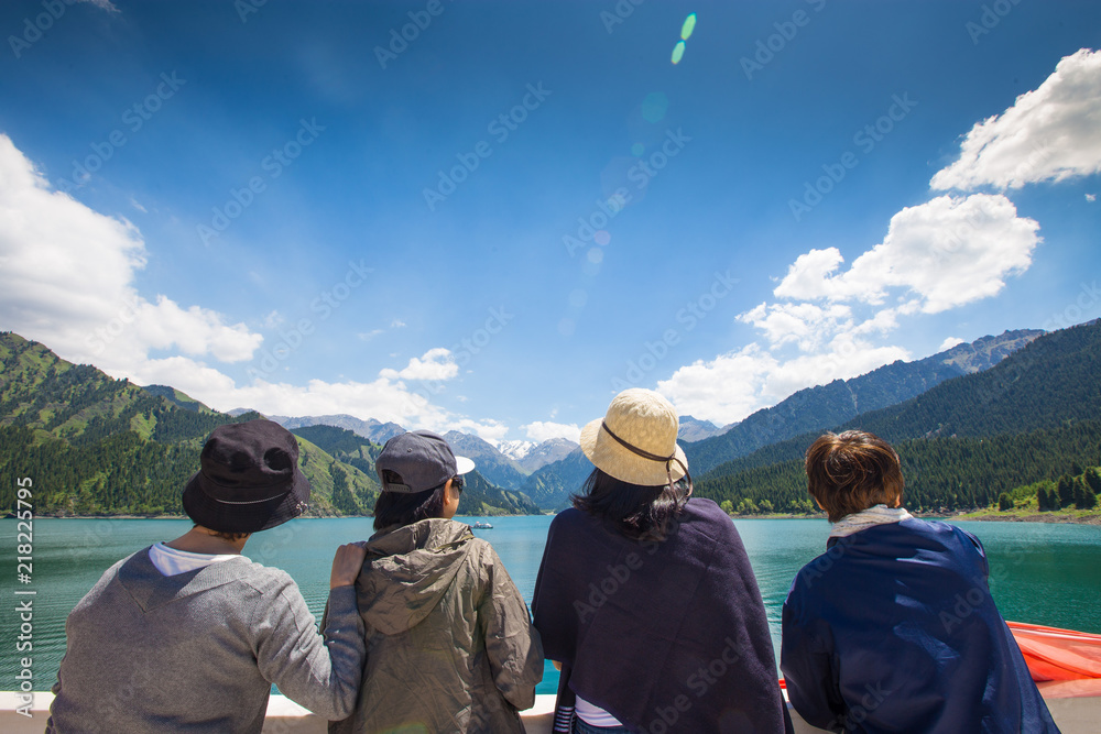 Back side rear View of Happy Friends Sisters sitting with raised Hands up job done, Women look and point success victory to scenic spot landscape distance in summer vacation holiday