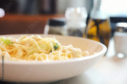 alfredo spaghetti broccoli chicken white sauce in restaurant background