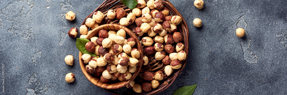 Hazelnuts and green leaves on gray background Hazelnuts and green leaves on gray background