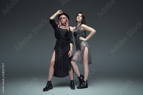 Two fashionable girls wearing black trendy outfits posing