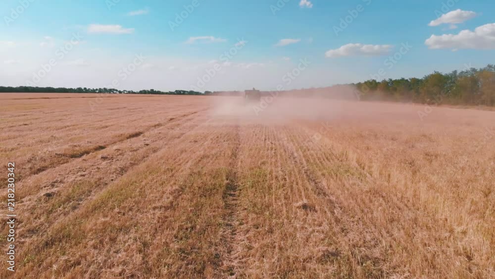 Aerial drone shot of a modern high-speed combine harvester working in a field at sunset. Harvesting in 4K. Aerial drone shot of a modern high-speed combine harvester working in a field at sunset. Harvesting in 4K.