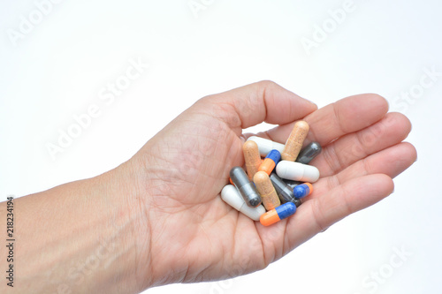 Mano mostrando un cóctel de diferentes medicamentos para el tratamiento de enfermedades como el VIH o simplemente como complementos alimenticios o adelgazamiento photo