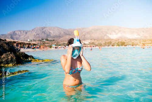 Portrait of summer girl, vacation fun woman wearing a snorkel scuba mask while swimming in ocean water. Travel holidays