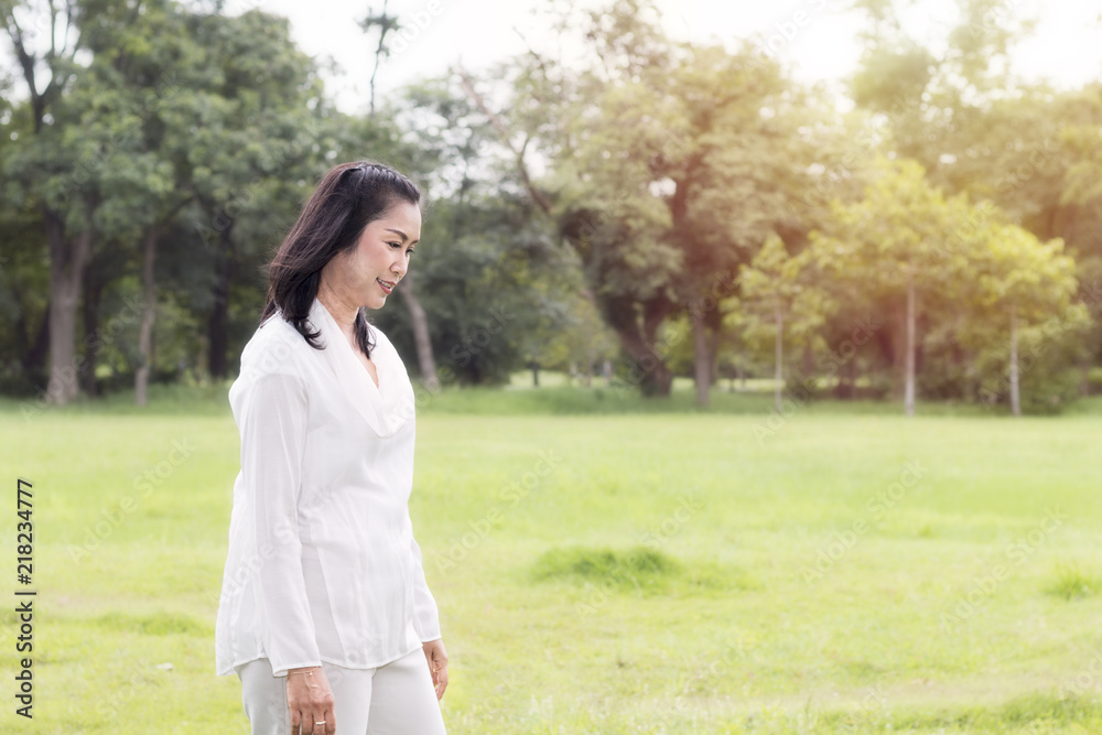 Beautiful portrait of lovely middle aged woman smiling and relaxing at the park.Copy space. Beautiful portrait of lovely middle aged woman smiling and relaxing at the park.Copy space.