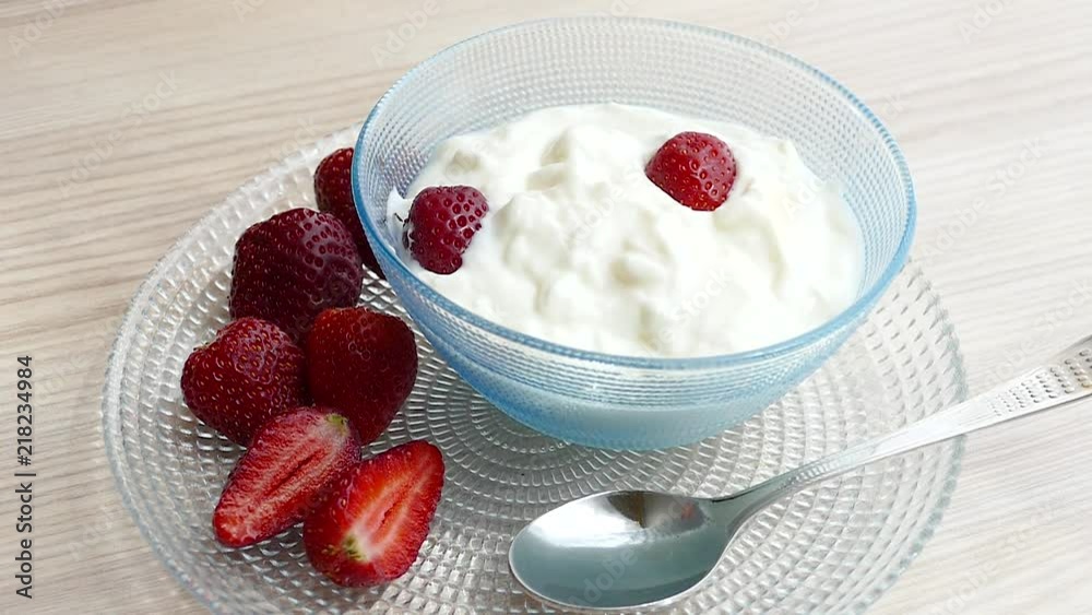 A healthy breakfast with homemade yogurt, strawberry and sugar sprinkles. Slow Motion video A healthy breakfast with homemade yogurt, strawberry and sugar sprinkles. Slow Motion video