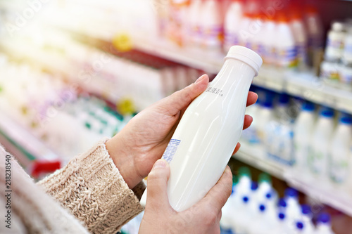 Buyer hands with bottle of milk at grocery