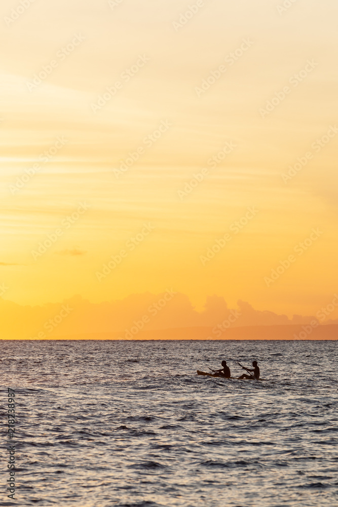 Silhouette of Two People Paddling in a Boat During Sunset.