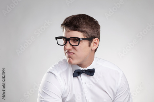 portrait dissatisfied young man with glasses photo