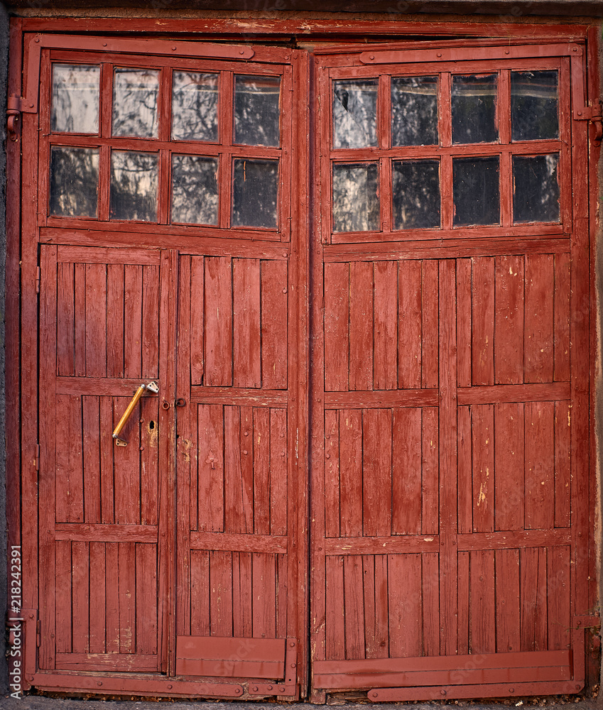 old red barn door with small windows reflection