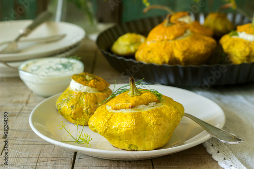 Pattypan squash or pumpkins stuffed with ricotta with basil and dill and served with sour cream sauce. Vegetarian food.